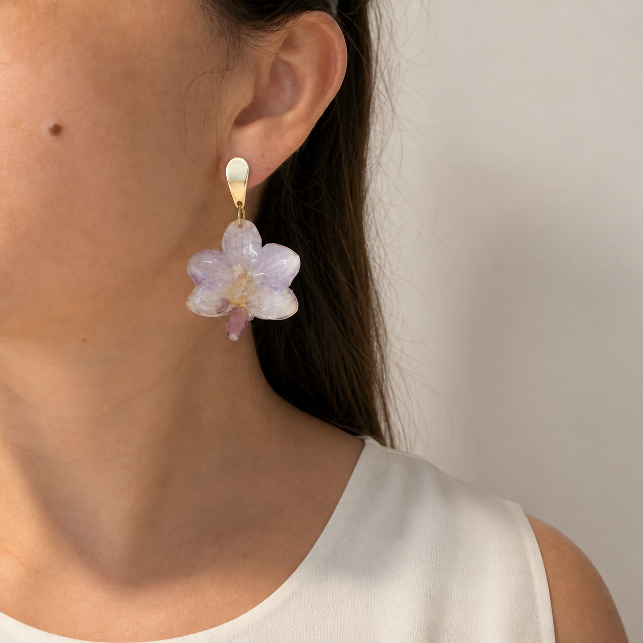 Lavender orchid drop earring worn by a model