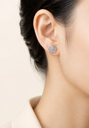Blue forget-me-not resin stud earrings worn on the ear