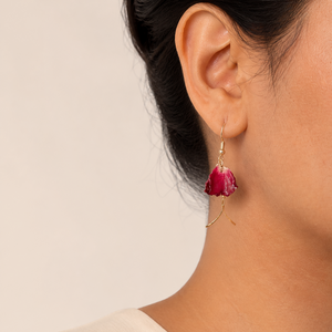 Deep red orchid stem earrings worn on the ear