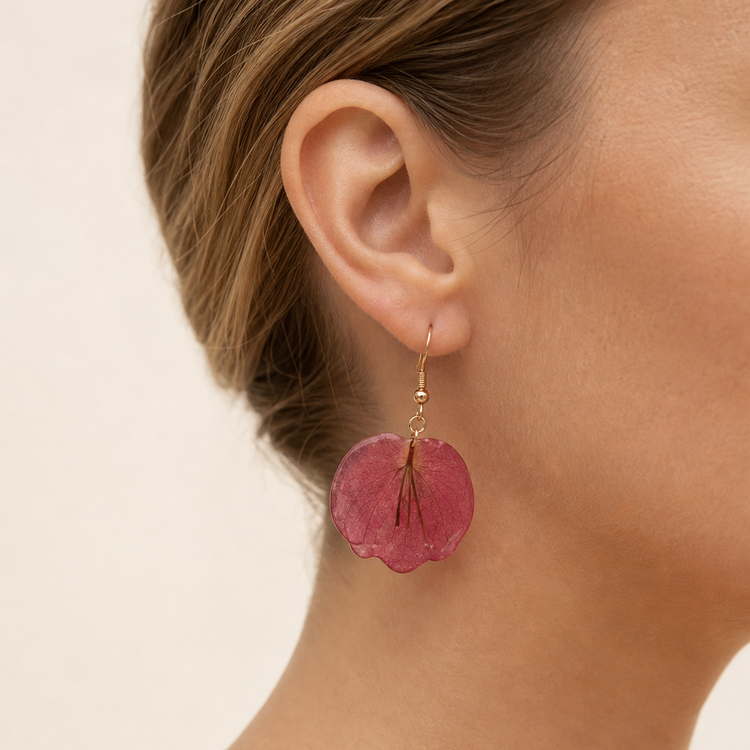 Pink petal resin drop earrings worn on the ear