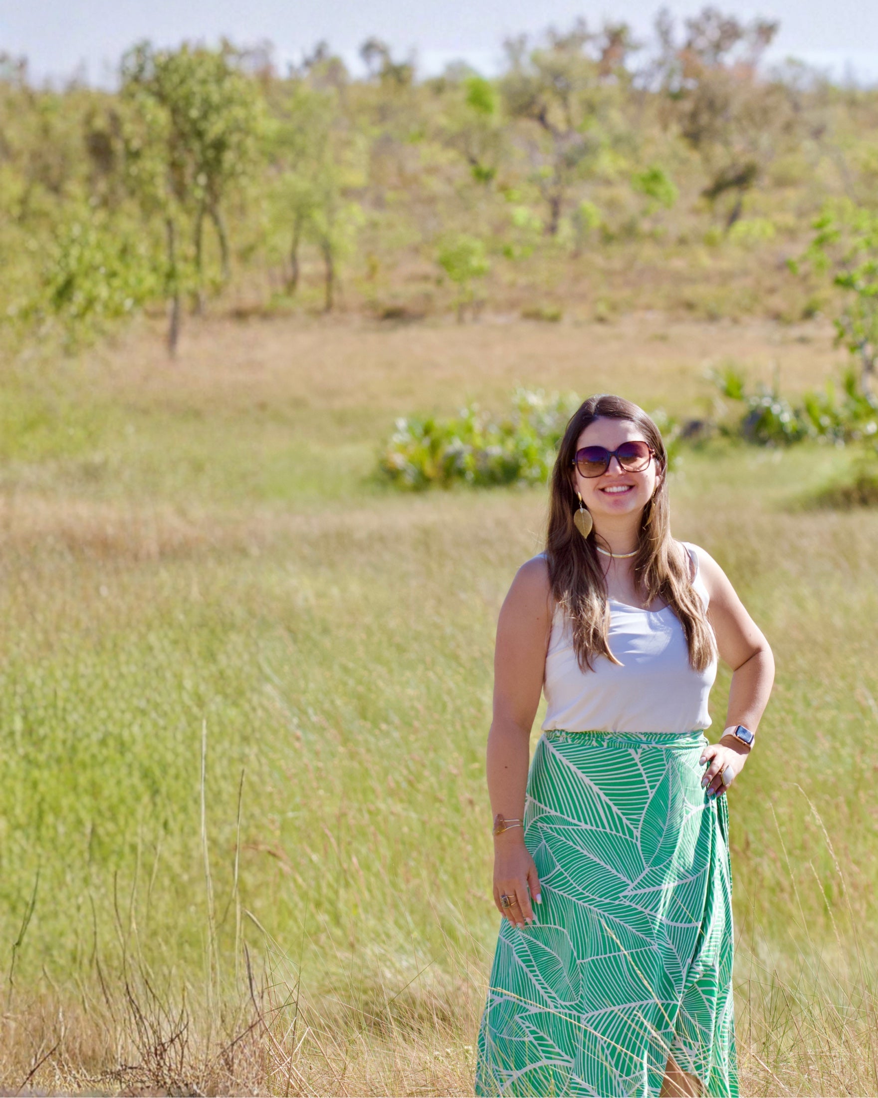 Daiane standing in the Brazilian countryside surrounded by native landscape